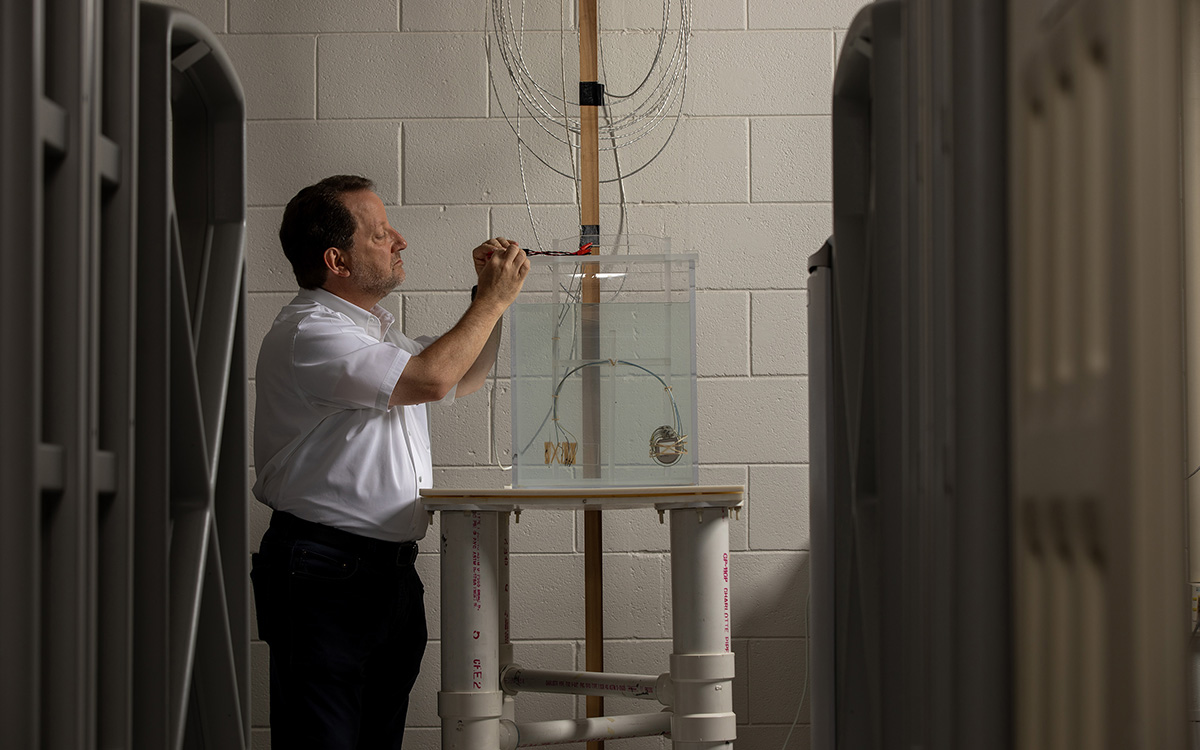 Security and logistical systems produced by various manufacturers surround a cart holding a cardiac resynchronization therapy defibrillator operating inside a torso simulator to simulate potential interactions between the device and the systems. Shown is Ralph Herkert, director of GTRI’s Medical Device Test Center. 