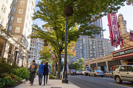 people walk down the street in front of the Fox Theater